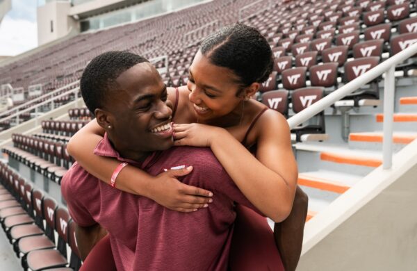 Boy posed giving friend a piggy back ride at Lane Stadium