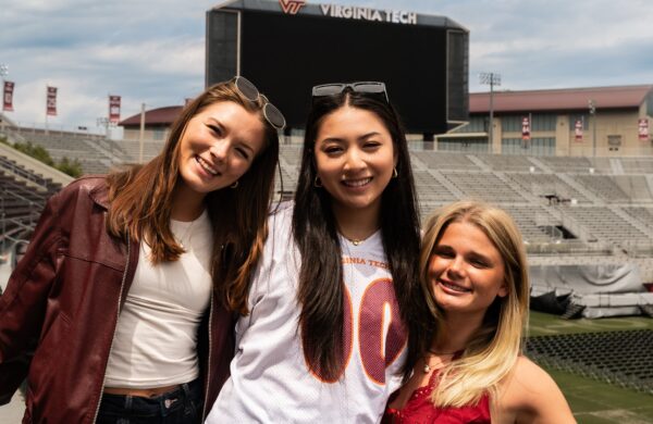Friends posing in the stands of Lane Stadium