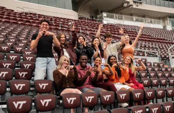 Group of friends cheering in the stands of Lane Stadium