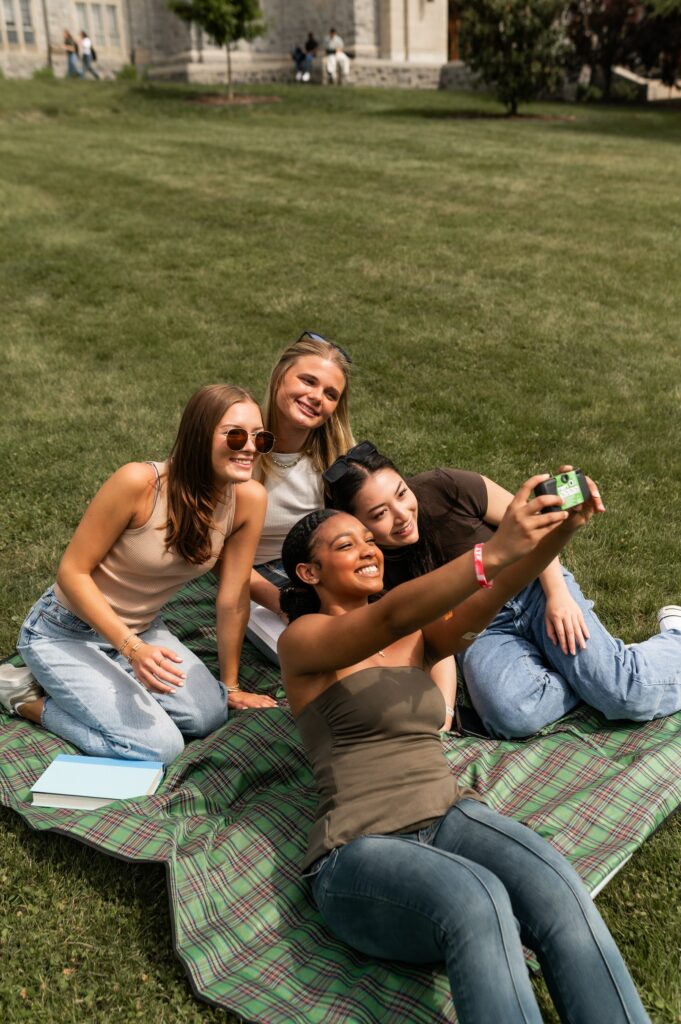 Group of girl friends taking a selfie on a disposable camera