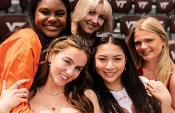 Group of young women in Virginia Tech colors at the football stadium