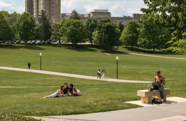 Students relaxing in the grass on a sunny day on the Virginia Tech campus