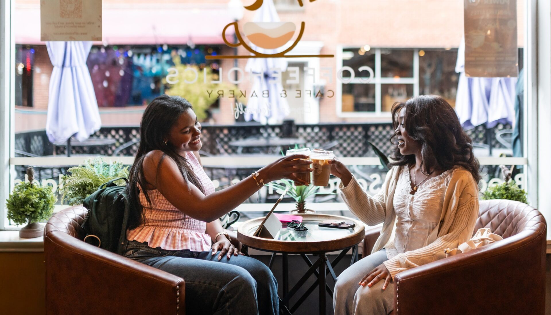 Two girl friends having coffee at a cafe near Heyday Blacksburg